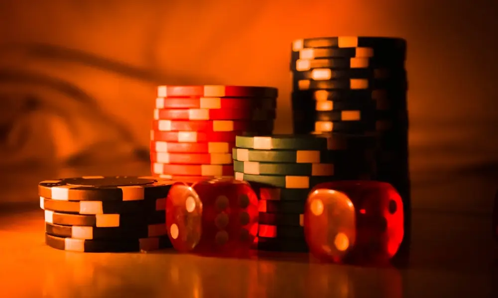 Stacks of casino chips on a table under warm light